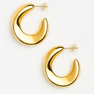 Pendientes aro dorado sculptural 18K con diseño moderno y elegante sobre fondo blanco.