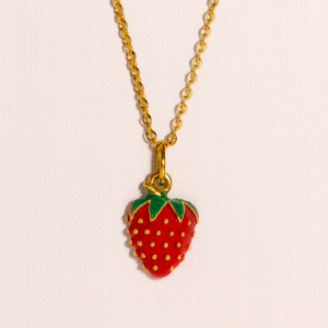 Charm de fresa esmaltada en rojo con detalles dorados y cadena dorada