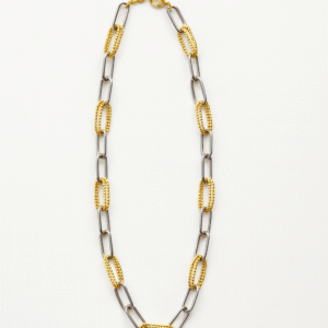 Collar bicolor con eslabones dorados texturizados y eslabones plateados lisos sobre fondo blanco.