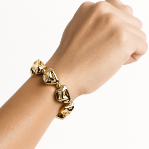 Pulsera de cuentas doradas orgánicas con diseño escultural mostrada en la muñeca.